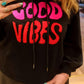 SUDADERA CON CAPUCHA ACOGEDORA 'GOOD VIBES' EN NEGRO CON DETALLES EN ROSA FUERTE Y ROJO