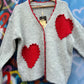 THE 'LOVE IS' SUPERSOFT FLUFFY CARDIGAN WITH APPLIQUE KNITTED HEARTS IN BLACK OR PALE GREY